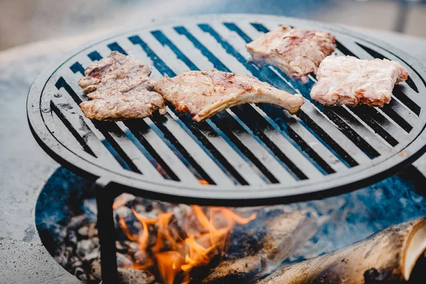 Vepřová žebírka a steak vařené na grilu, open fire street food festival — Stock fotografie