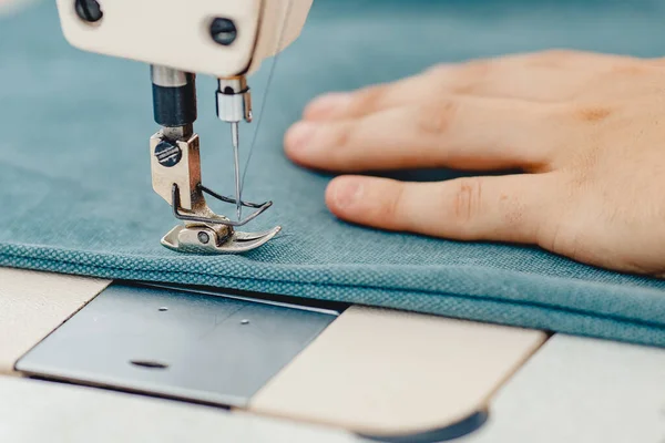 Manos masculinas sastre trabajando en la máquina de coser, haciendo el bolso del comprador de la tela — Foto de Stock