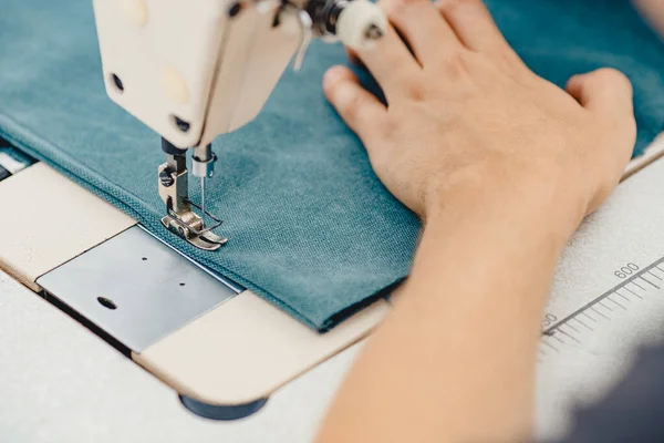 Manos masculinas sastre trabajando en la máquina de coser, haciendo el bolso del comprador de la tela — Foto de Stock