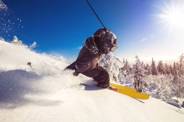 Güneşli bir günde tepeden aşağı kayak yapan kayakçı taze kar beşiği. Aşırı yüksek hız, soğuk toz dağılır. — Stok fotoğraf