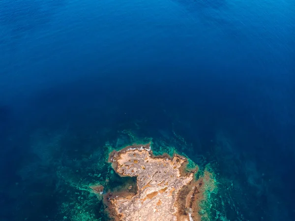 Vista superior Mar azul azulado con olas golpeando en la playa y rocas. Foto aérea . — Foto de Stock