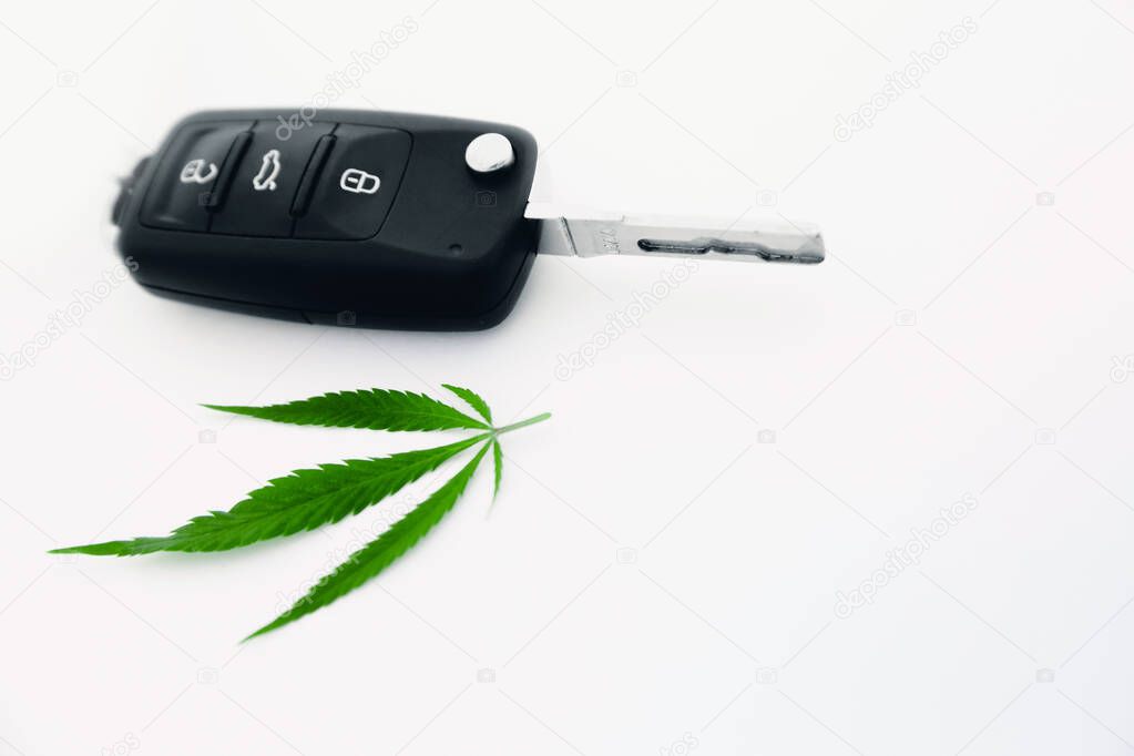 Cannabis leaf car keys on white background, concept driving under drug