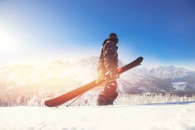 Kayakçı elinde kayakla dağın tepesinde durur. Kış aşırı serbest dolaşım konsepti