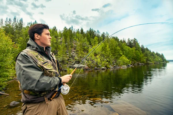 Pescatore con canna pesca a mosca in montagna fiume autunno spruzzi d'acqua — Foto Stock