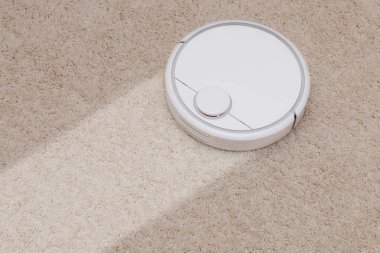 Robotik kablosuz akıllı elektrikli süpürge beyaz halı üzerinde çalışıyor. Hizmetten önce ve sonra kavram