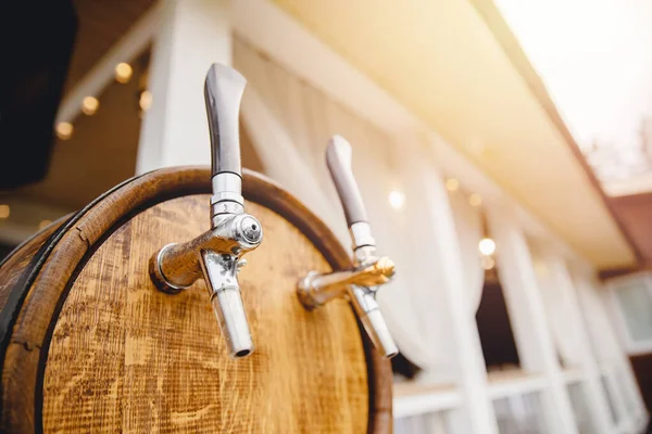 Close up of wooden keg for beer with two taps bottling drinks at party