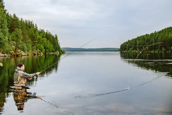 Pescador con varilla pesca con mosca en el río de montaña verano salpicaduras de agua —  Fotos de Stock