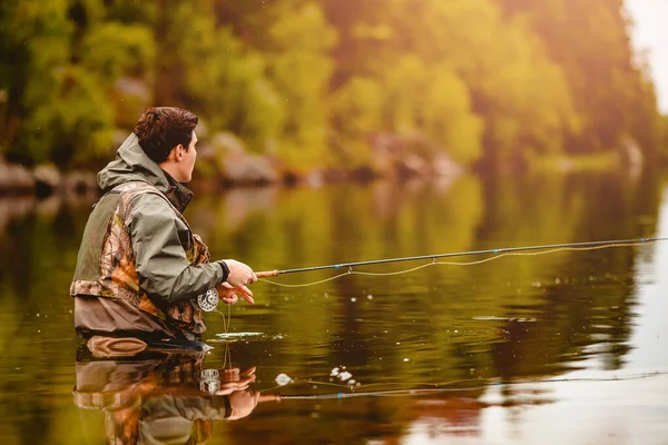 Pescatore con canna pesca a mosca in montagna fiume estate spruzzi d'acqua — Foto Stock