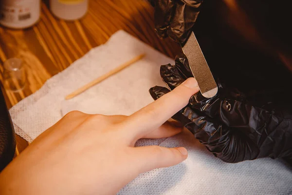 Człowiek robi manicure w salonie piękności, mistrz tnie paznokcie — Zdjęcie stockowe
