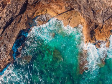 Kayalık kıyıları ve berrak suları olan mavi bir göl. Üst Görünüm