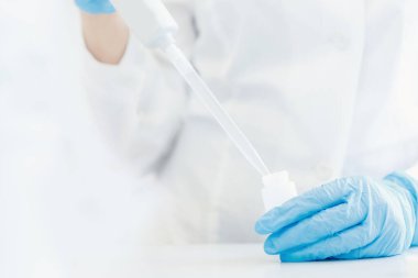 Kaliteli suyun bileşimini analiz eden kimya laboratuvarı, laboratuvar önlüklü doktor pipeti tutuyor.
