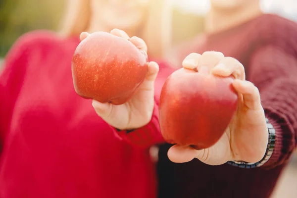 Healthy food, couple share holding red apples in their hands. Diet co-nutrition concept