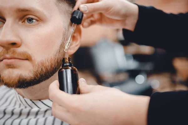 Barbiere fa olio per la cura e la crescita della barba, barbiere — Foto Stock