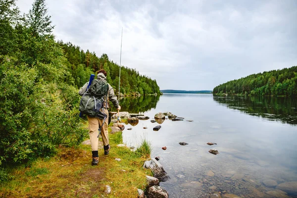 Hombre pescador va pesca con mosca en el río de montaña — Foto de Stock