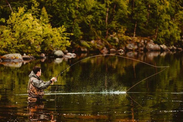 Pescatore con canna pesca a mosca nel fiume di montagna — Foto Stock