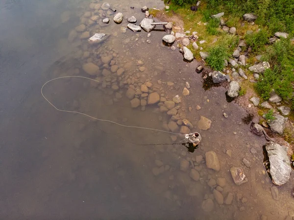 ブーツで山の川の漁師の男は、午前中に釣りサーモンフライ。空中展望 — ストック写真