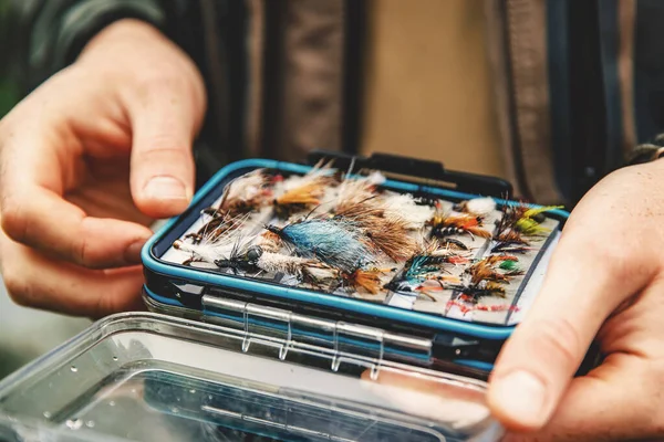 Caja moscas para la pesca con mosca en la mano pescador — Foto de Stock