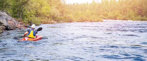 Chlápek na kajaku pluje po řece. Whitewater jízda na kajaku, extrémní sportovní rafting — Stock fotografie