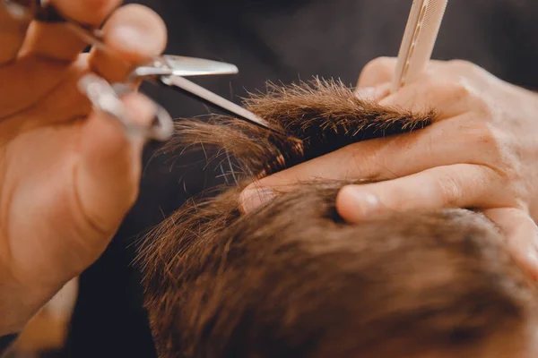 Barber master hairdresser does hairstyle with scissors and comb. Concept Barbershop — Stock Photo, Image