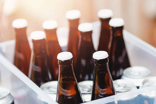 Пиво в стеклянных бутылках и банках хранится для вечеринки — стоковое фото