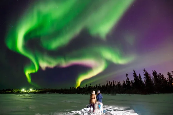 Dos chicas miran las luces del norte, que se extiende más allá del horizonte —  Fotos de Stock