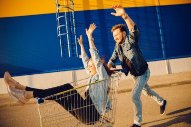 Alışveriş için markete tramvayla koşan mutlu aile çifti. Yaşam tarzı kavramı