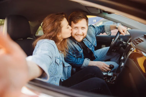 Konzept Sommerurlaub. junge Frau küsst Fahrer Mann auf Wange, Selfie-Liebhaber Paar im Auto — Stockfoto