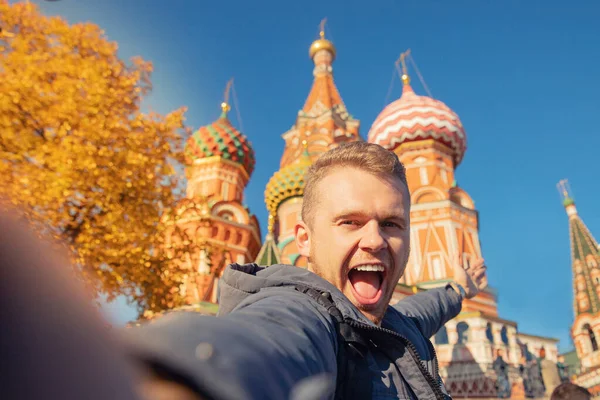 Мужчина-турист делает селфи на фоне Красной площади Собора Василия Блаженного в Москве осенью. Концепция путешествия — стоковое фото