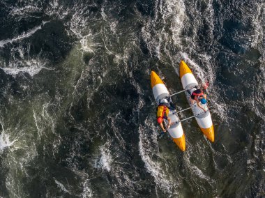 Kanodaki adam dağ nehrine yelken açıyor. Beyazsu kano sporu, rafting. Havadan üst görünüm