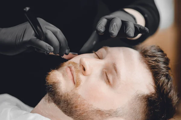 Un salon de coiffure. Coiffeurs coiffeur cheveux et barbe avec rasoir dans le salon — Photo