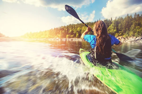 Chica joven es kayak con salpicaduras de paleta en aerosol. Día de verano, concepto de viaje — Foto de Stock