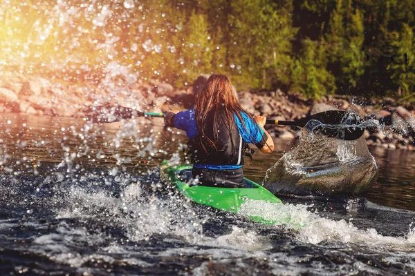 Chica joven es kayak con salpicaduras de paleta en aerosol. Día de verano, concepto de viaje — Foto de Stock