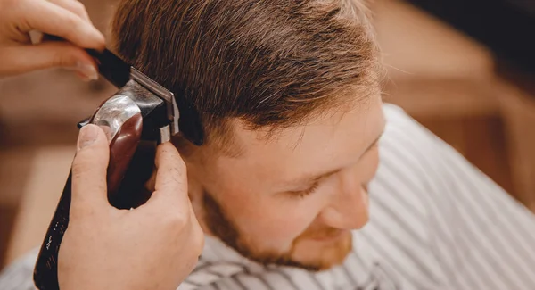 Barber master hairdresser does hairstyle scissors and comb. Concept Barbershop