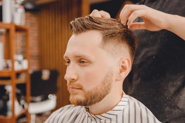 Cabeleireiro mestre barbeiro faz estilo com tesoura e pente. Conceito Barbearia — Fotografia de Stock