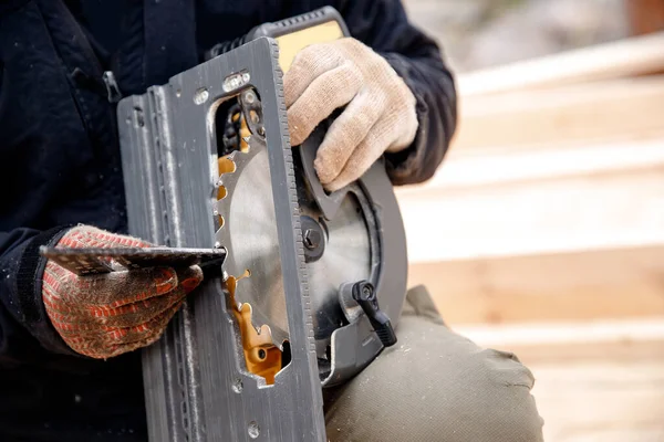 Constructor muele dientes de hierro utilizando herramienta de sierra circular portátil para cortar madera — Foto de Stock