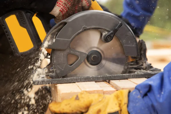 Constructor utiliza herramienta de sierra circular portátil para cortar madera — Foto de Stock
