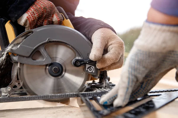 Stavitel používá přenosný kruhový pilový nástroj k řezání dřeva — Stock fotografie