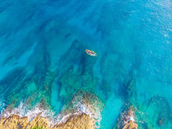 Barco tradicional de pescadores malteses al amanecer pescando cerca de la costa de marsaxlokk. Agua de mar azul turquesa, vista superior . — Foto de Stock