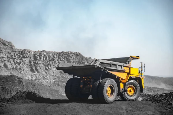 Industria minera a cielo abierto. Camión minero amarillo para movimiento de carbón a cargas de excavadoras — Foto de Stock