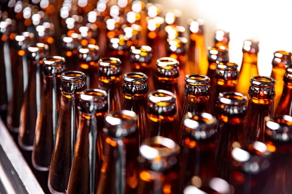 Close up conveyor neck of clean dark glass bottle — Stock Photo, Image