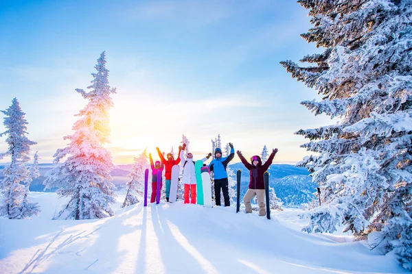 Snowboard 'culardan oluşan bir grup ve kayakçı kar kayaklarıyla şafakta kış ormanı gündoğumunda güneşlenirler. Yaşam tarzını, seyahatini kavra. — Stok fotoğraf