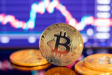 Grafik diyagramının arka planında altın Bitcoin kripto para birimi
