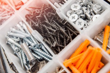 Küçük inşaat eşyalarıyla dolu bir çanta. Vidalardan, çapalardan, çivilerden oluşan metal alet kutusunu ayarla