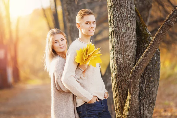 Schöne Mädchen umarmt Kerl im Herbst Park, verliebtes Paar — Stockfoto