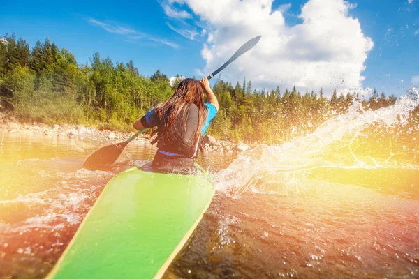 La giovane ragazza sta facendo kayak con spruzzi di spray paddle. Giornata estiva, concetto di viaggio — Foto Stock