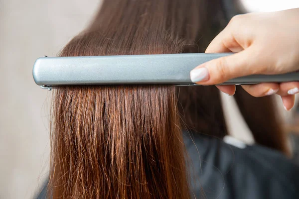 Närbild händer professionell frisör skönhetssalong, plattång locktång kvinnligt hår — Stockfoto