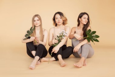 Çok kültürlü Asyalı kadınların portresi, doğal yeşil yapraklı beyaz tenli sarışın manken kız. Moda florası güzelliği kavramı