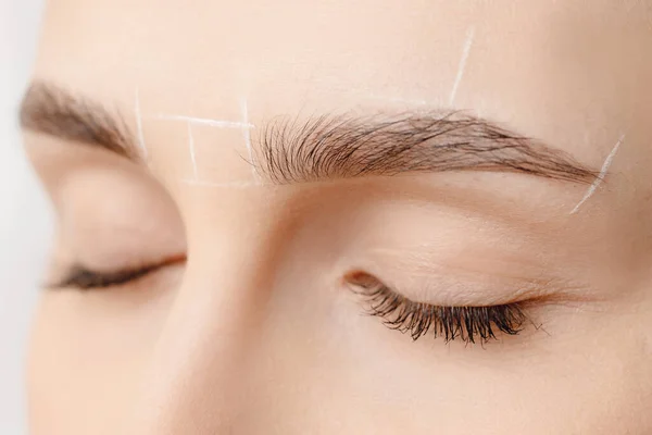 White marking for eyebrow correction on woman face