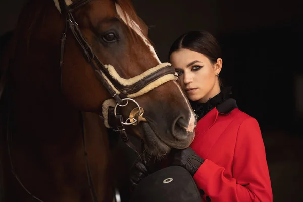 Femme jockey cavalier étreint cheval brun avec les yeux fermés. Concept amour animaux — Photo
