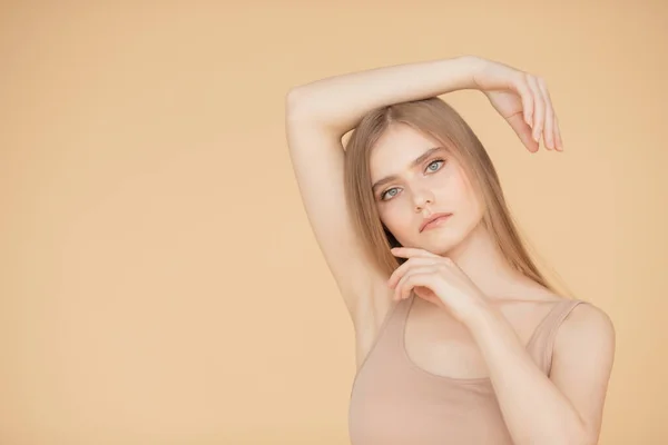 Hermoso retrato de mujer joven sobre fondo beige aislado, cuidado de la piel y el cabello concepto de cara de belleza —  Fotos de Stock